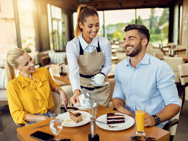Professional hospitality staff serving customers in restaurant