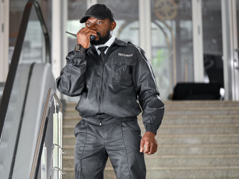 Professional security guard with radio in commercial building